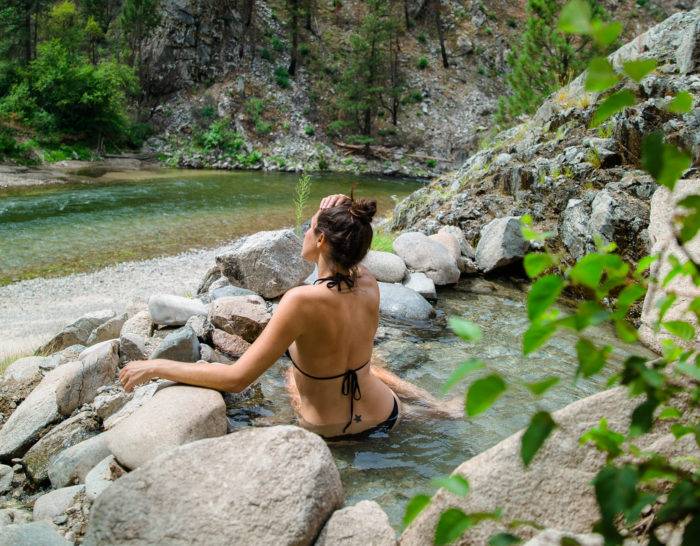 woman sitting in mountain hot spring