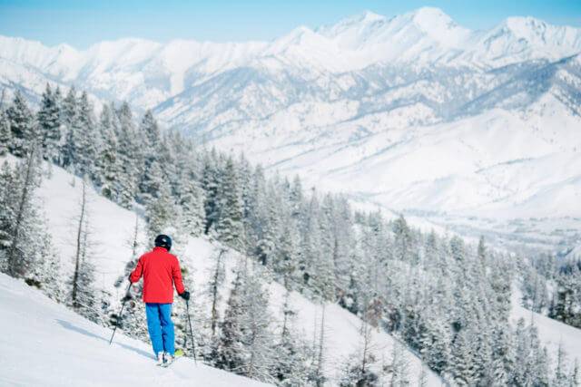 A person in snow gear skiing down a slope on Bald Mountain.