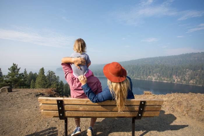 family on bench overlooking lake