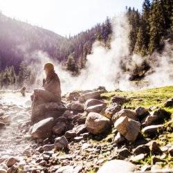 girl on rocks near steam