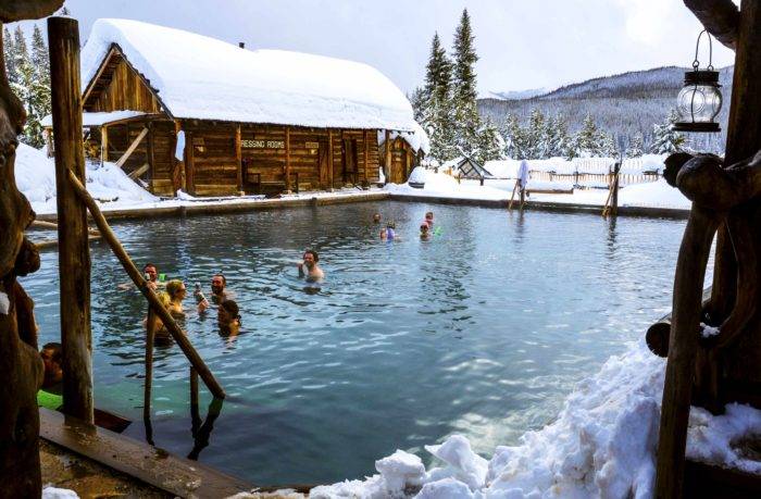 people soaking in rustic hot pool