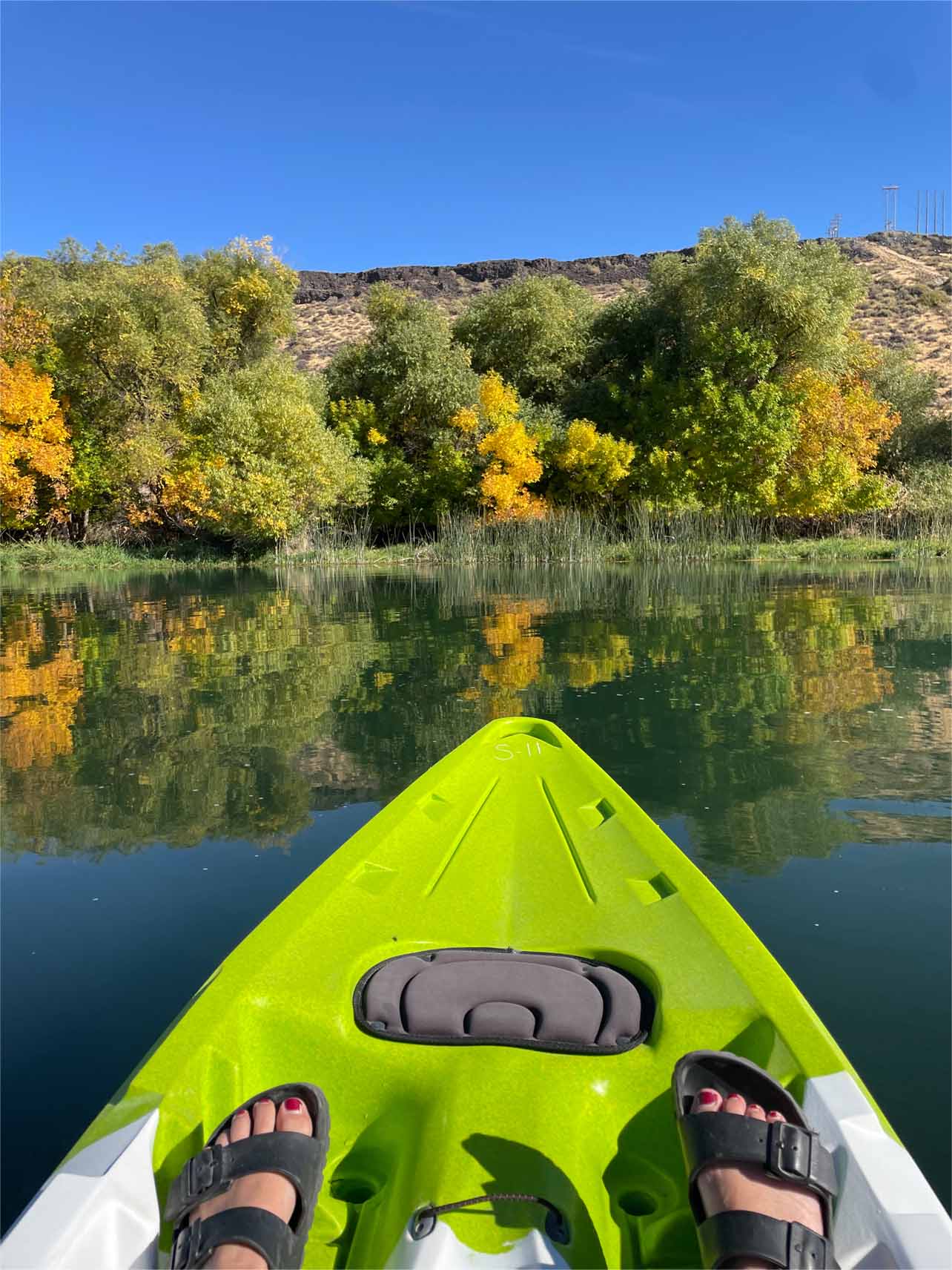 A bright kayak points towards lush landscapes atop the waters at Blue Heart Springs.