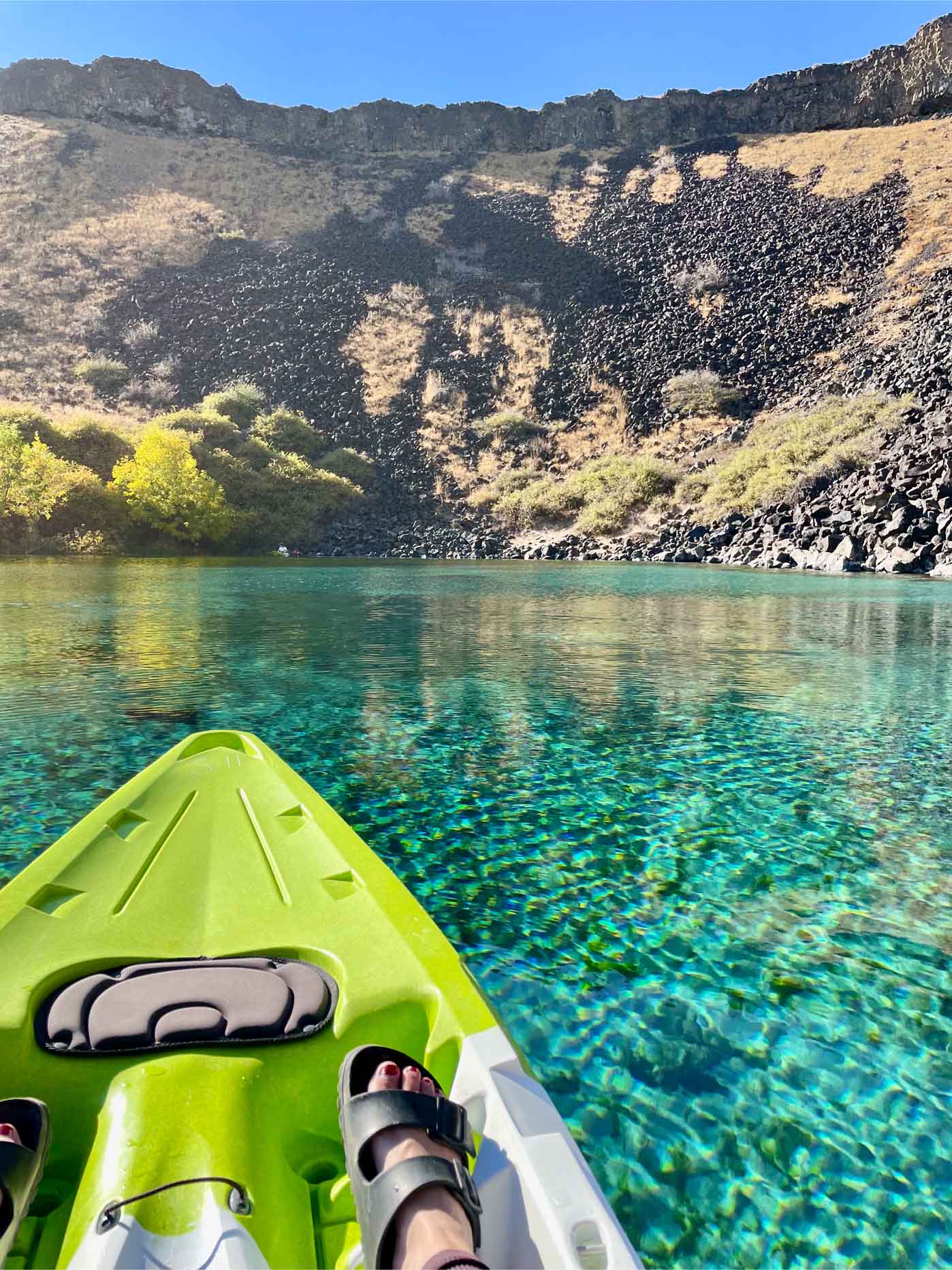 The jeweled turquoise waters ripple as a kayak glides into the Blue Heart Springs along the Snake River.