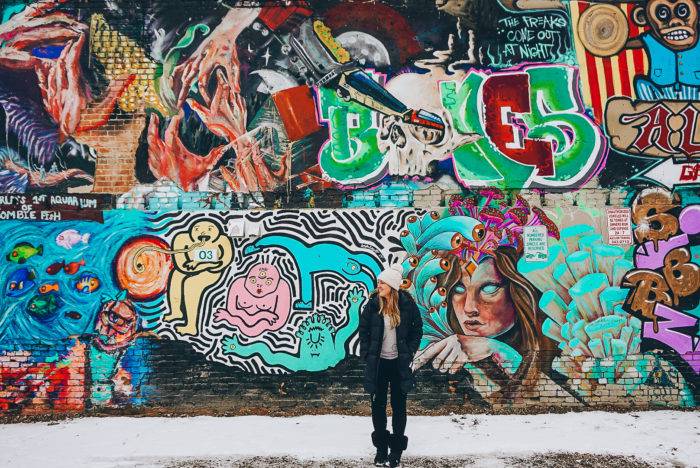 woman in front of graffiti wall