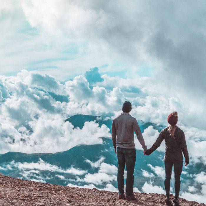 two people standing on a hilltop