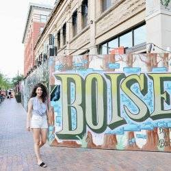 woman standing next a mural