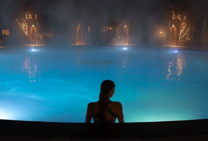 woman sitting in pool at night