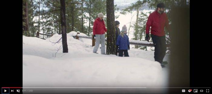 A family snowshoeing near a snow-covered lake in Idaho.