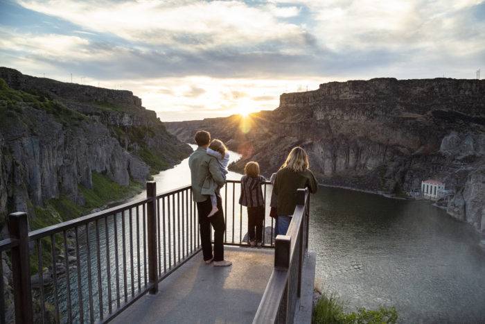 A family on the viewing deck watching the sunset at Shoshone Falls.