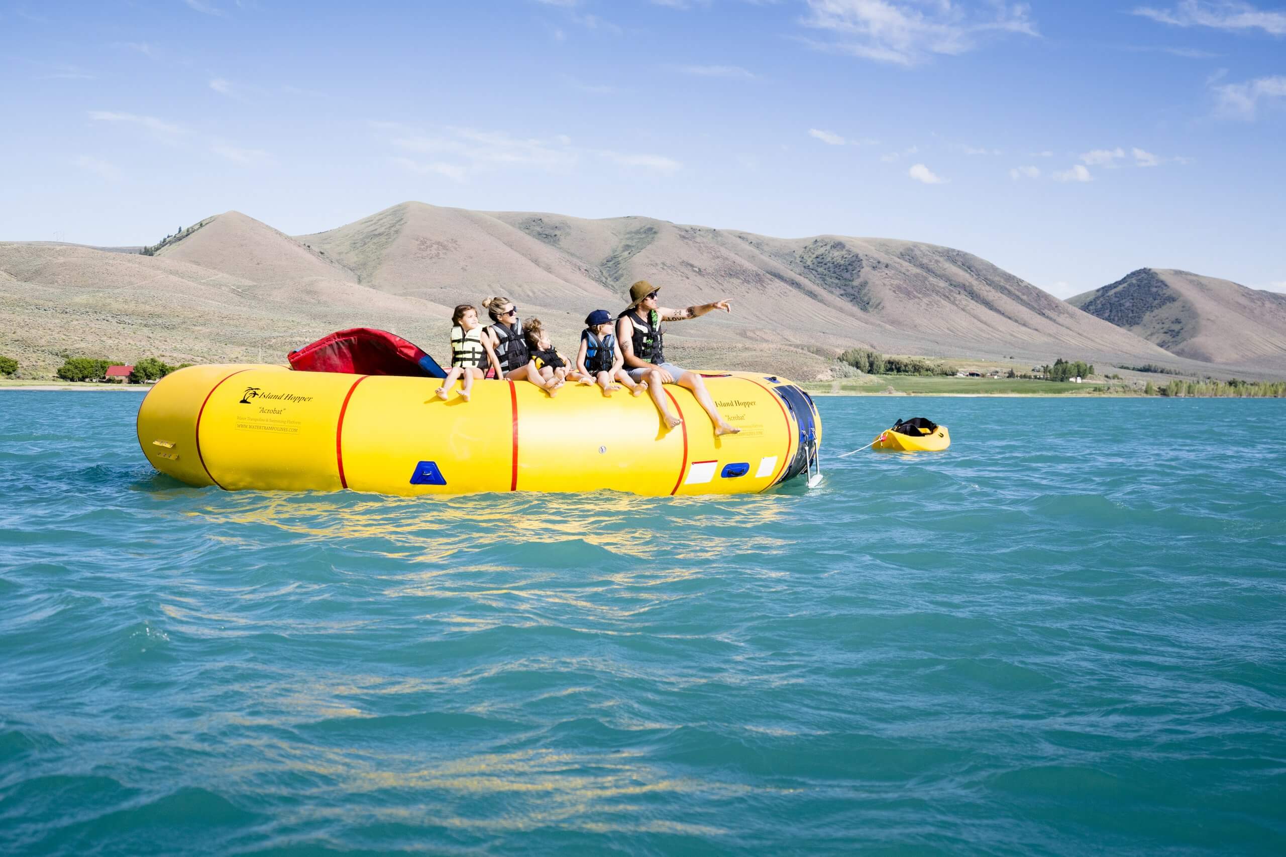 A family sitting on a water trampoline on a lake