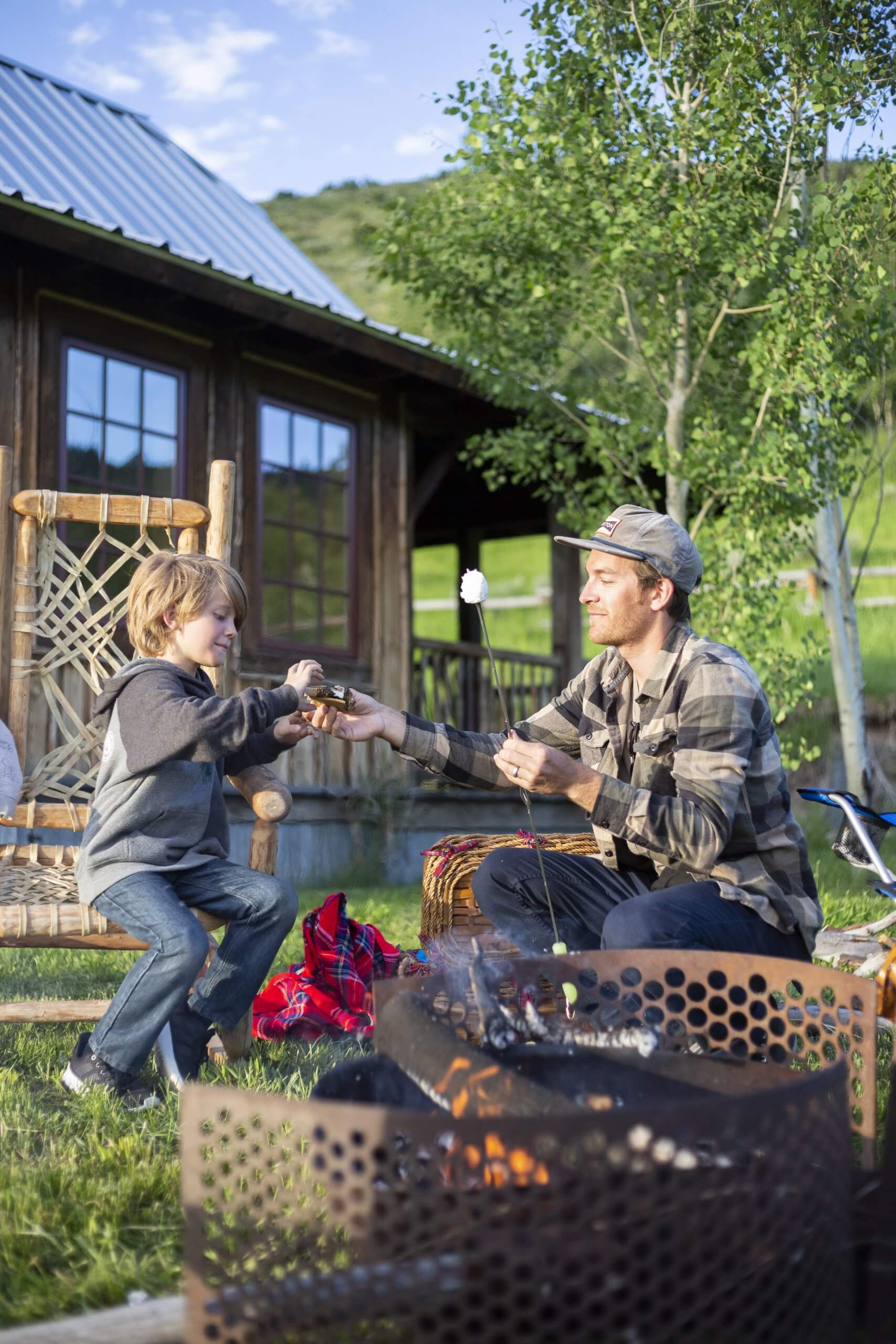 A father and son roasting marshmallows.