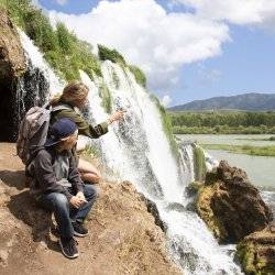 A mother showing her son a waterfall.