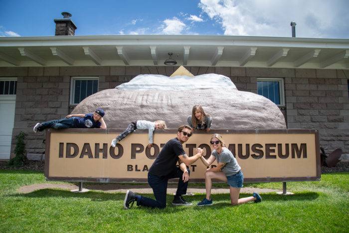 A family taking a family photo in front of the Idaho Potato Museum.