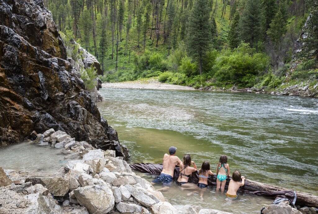 A family enjoying a soak in a natural hot springs.