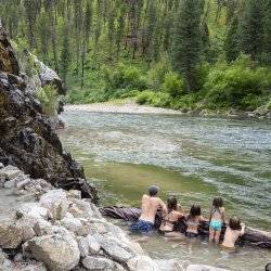 A family enjoying a soak in a natural hot springs.