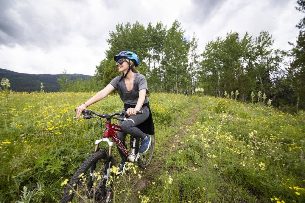 A woman mountain biking in a valley.