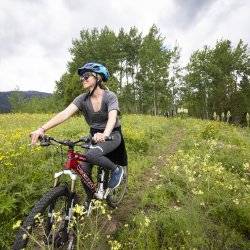 A woman mountain biking in a valley.