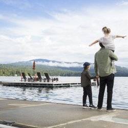 A father holding his child on the dock on Payette Lake.