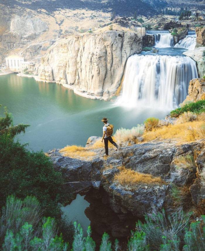 A man hiking near a waterfall.