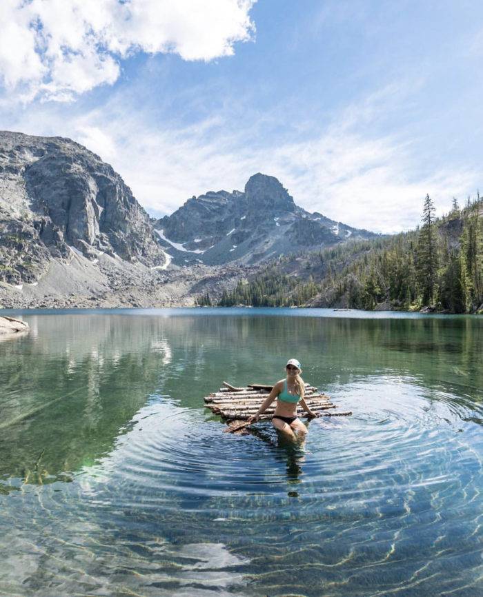 A woman floating in a mountain lake.