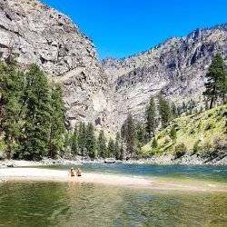 people sitting alongside river