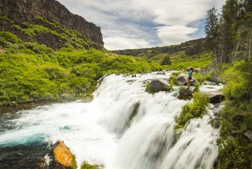 woman standing by waterfall