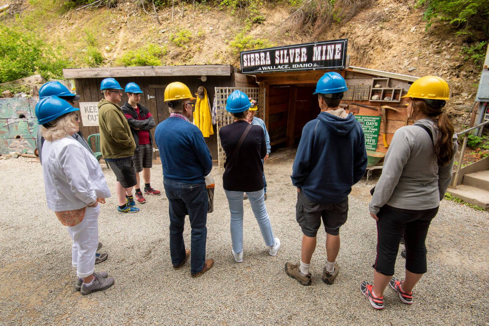 A group of people, all wearing hard hats, waiting outside the entrance to the Sierra Silver Mine.