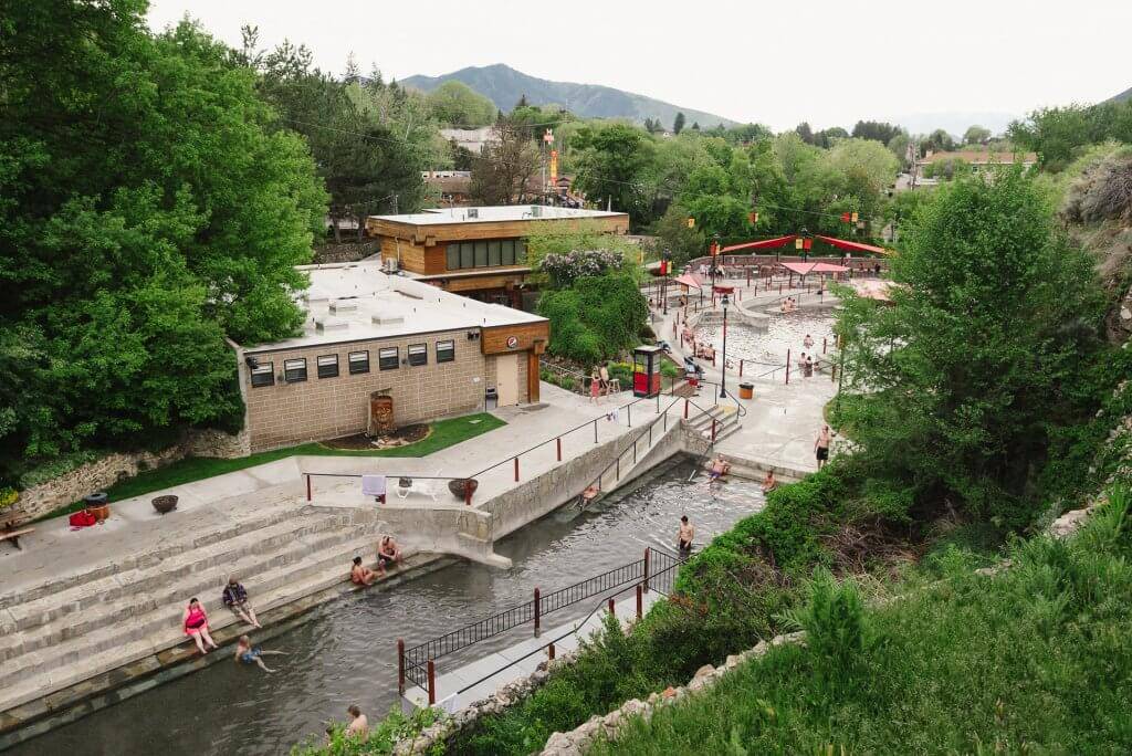 People enjoying multiple pools at a large hot springs facility.