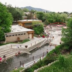 People enjoying multiple pools at a large hot springs facility.