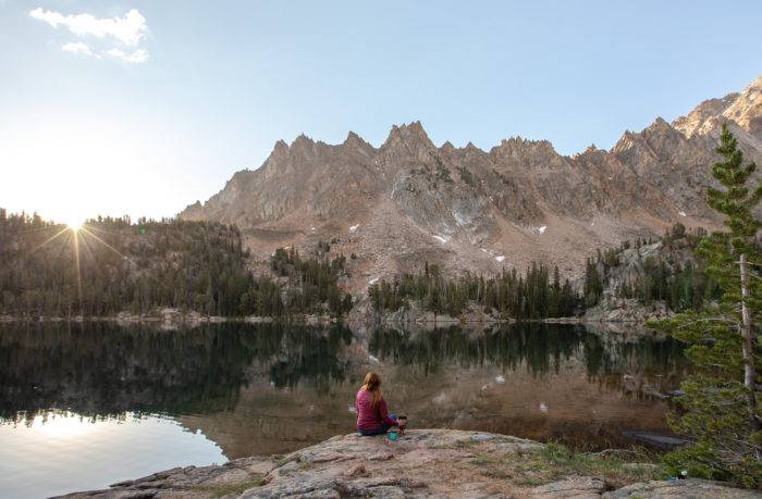 woman sitting at high mountain lake