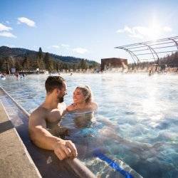 A couple smiles in an outdoor developed hot springs pool.