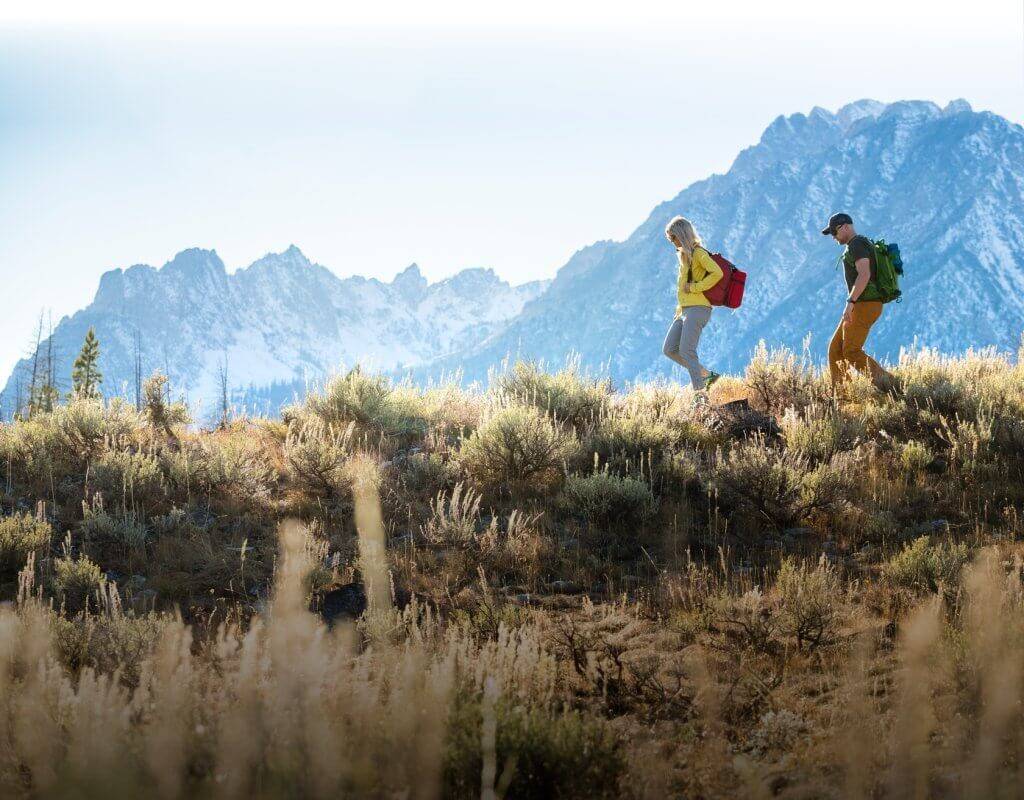 Two people hike along a ridge line. Explore Idaho's Regions With an Interactive Map of Idaho