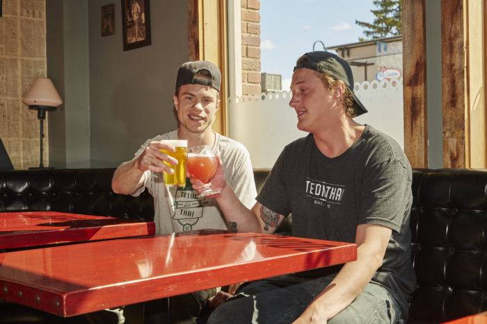 two men with beer glasses at teton thai