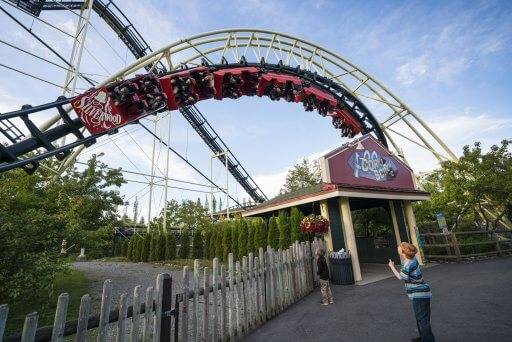 little boys watching people ride a twisting roller coaster at Silverwood Theme Park