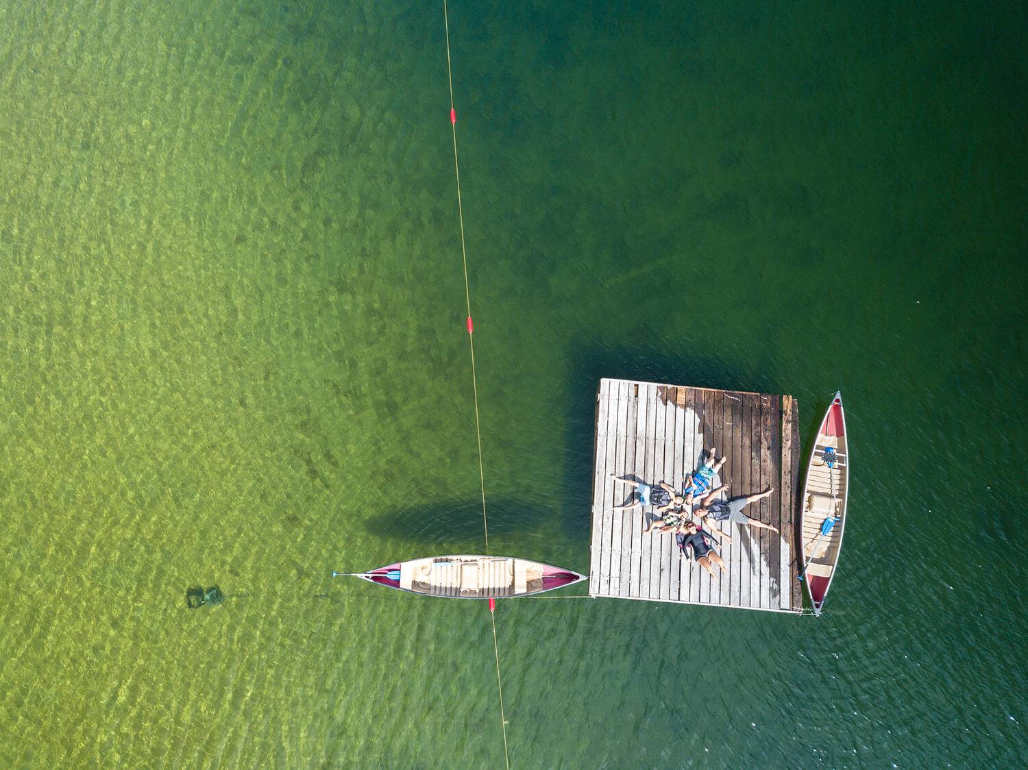 People laying on a deck in the middle of Priest Lake.