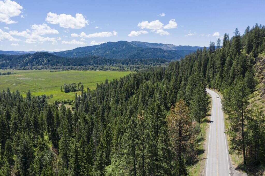 An aerial view of White Pine Scenic Byway carving through evergreen trees.