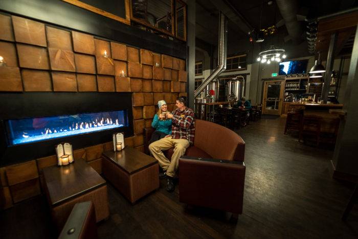 a couple sitting in front of a fire place