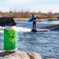 can of beer on a rock by a river