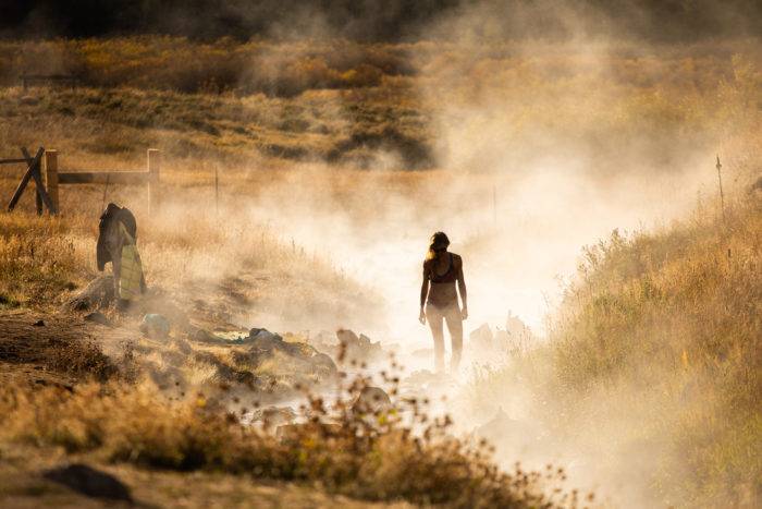 woman standing in steam of hot spring