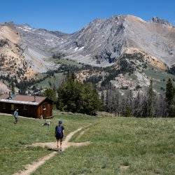 mountain cabin and hiker on trail