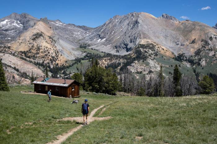 mountain cabin and hiker on trail