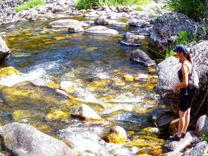 woman fishing in mountain stream