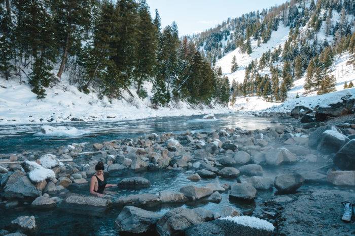 woman in snowy riverside hot spring near Stanley Idaho.