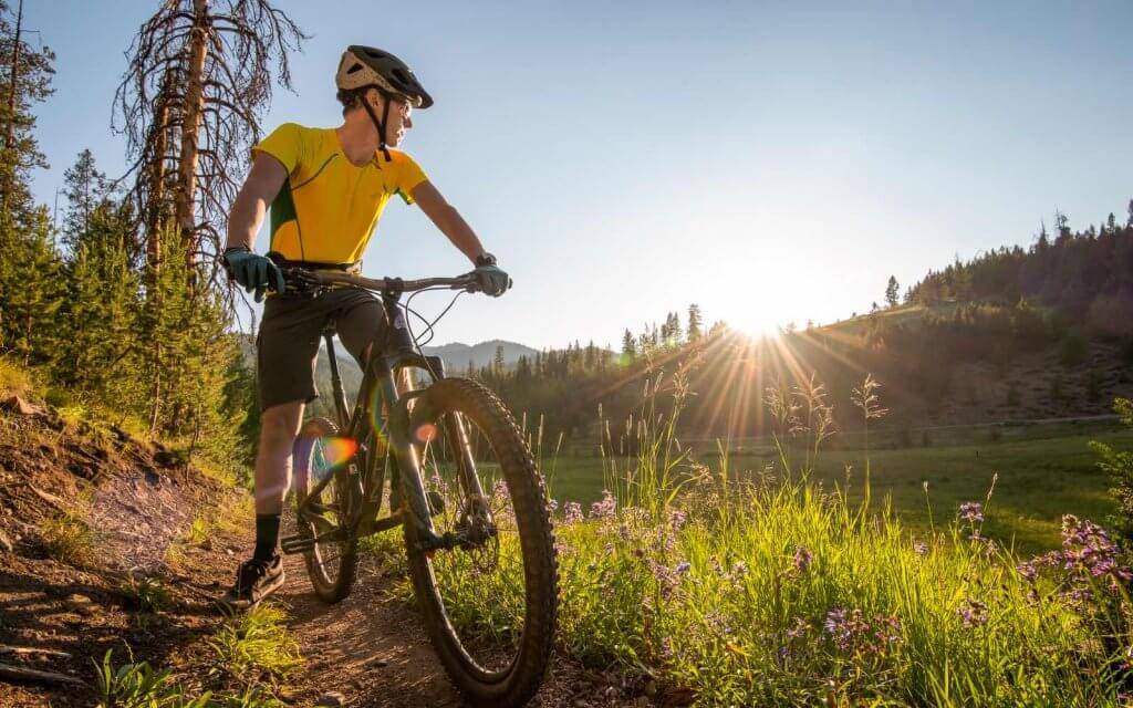 Mountain biker pausing on the trail side to admire the view of the trail around Galena Lodge