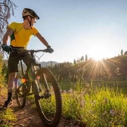 Mountain biker pausing on the trail side to admire the view of the trail around Galena Lodge