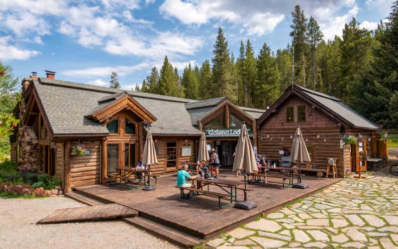 front view of Galena Lodge and people sitting outside at tables on the patio