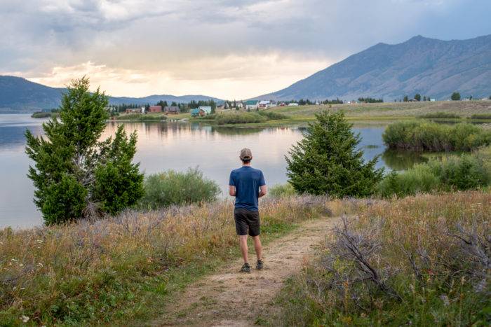 man on aspen loop trail looking at water