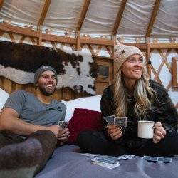 Relaxing on a bed, playing cards in Willow Glamping Yurt