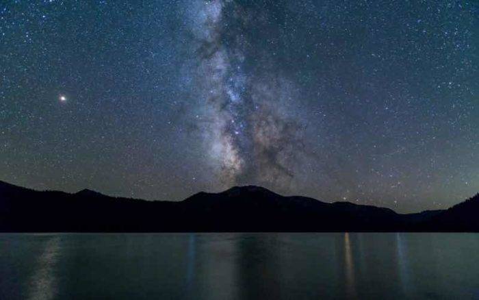 sprawling view of the night sky with mountains in the distance