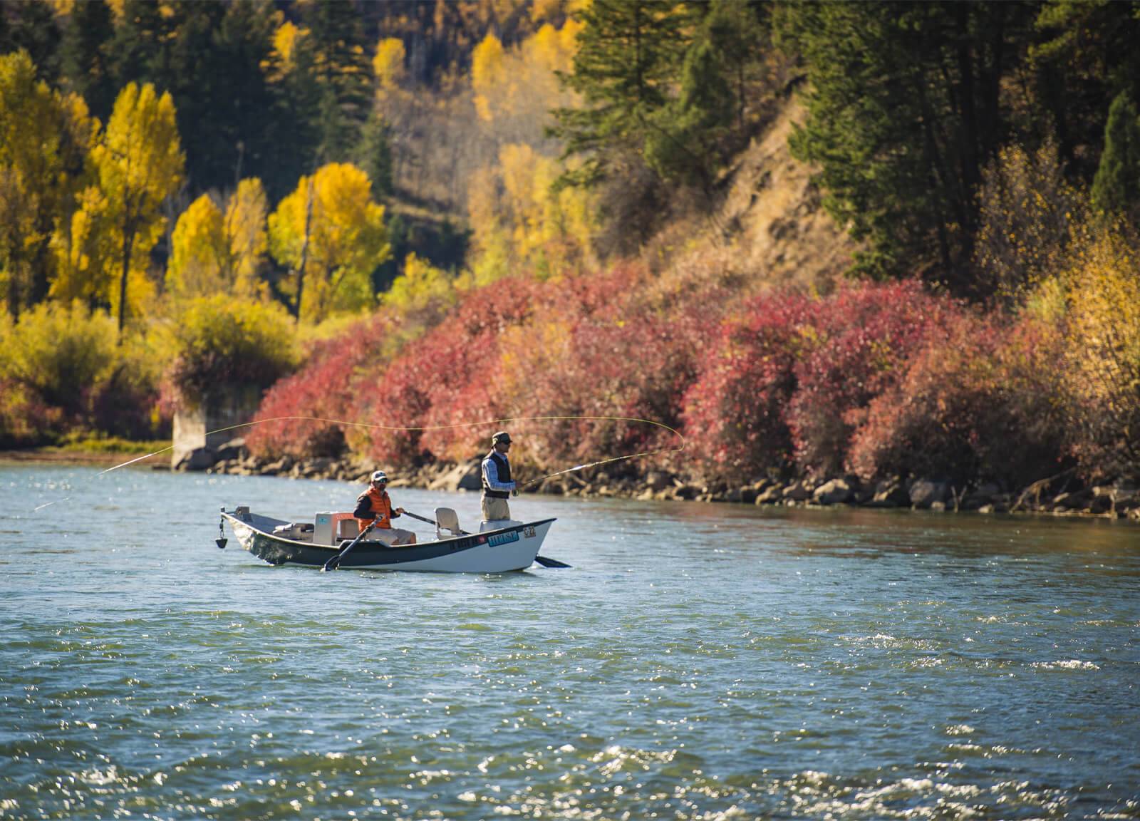 Two men fishing on the Snake River surrounded by fall colors.